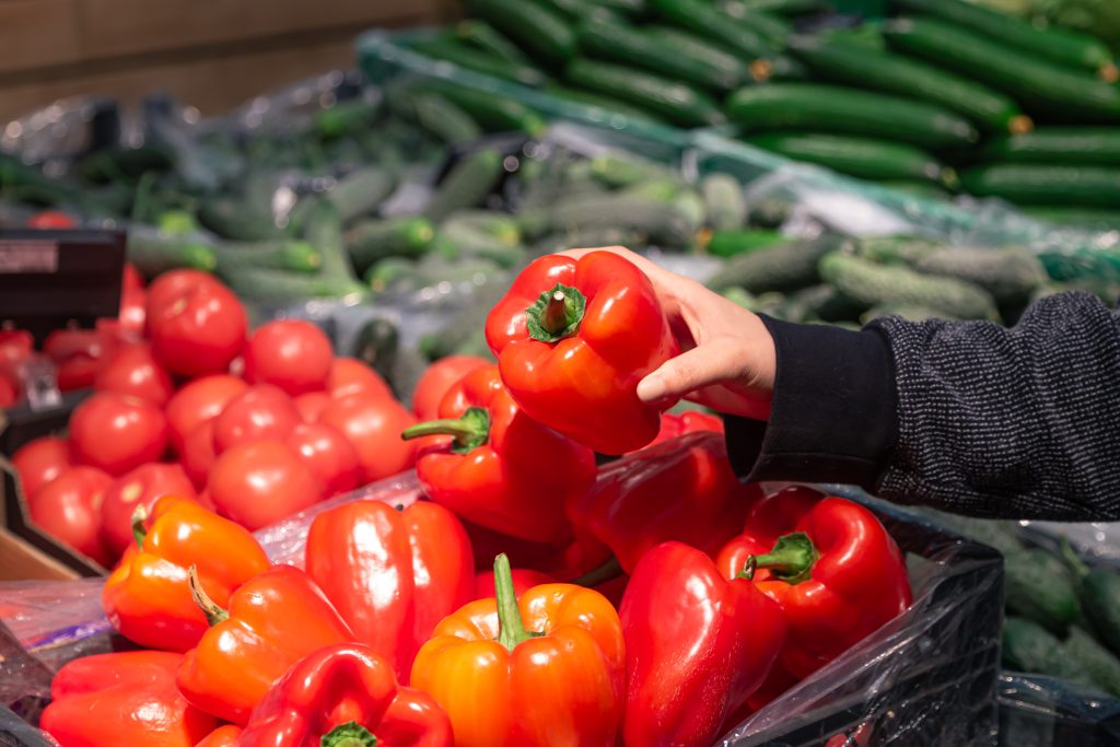 A Woman Chooses Bell Papers At A Grocery Store.